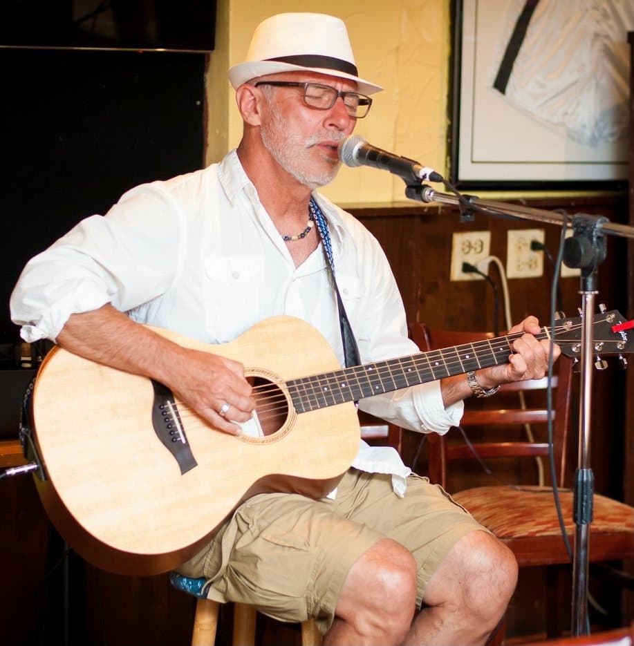 Pops singing and playing acoustic guitar at a live gig in Bermuda